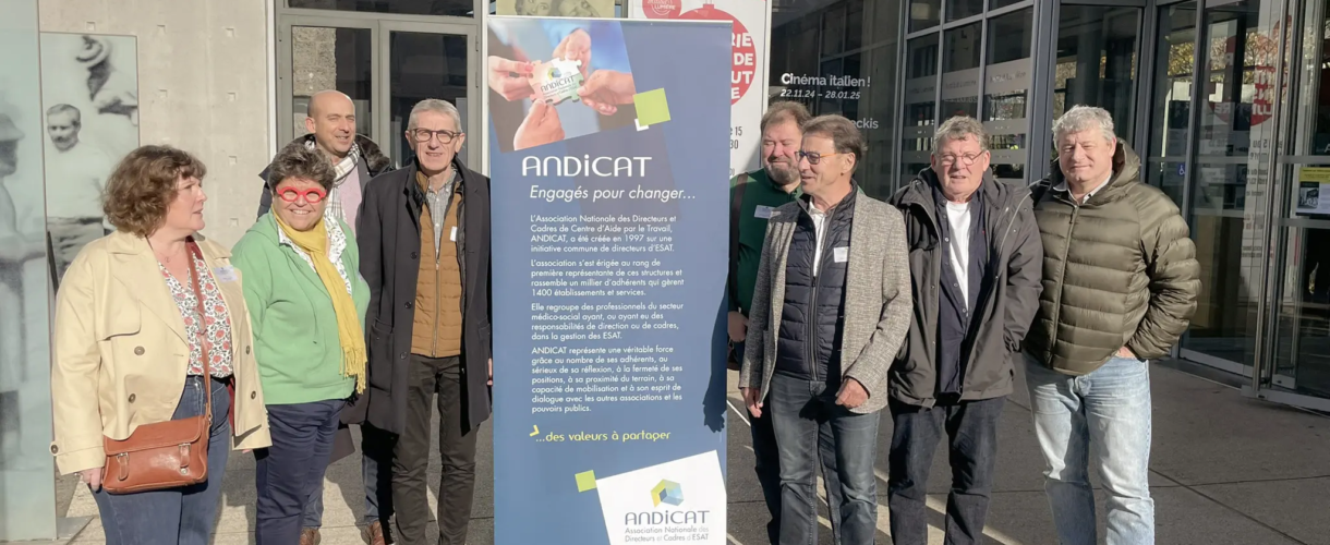 Membres du réseau ANDICAT réunis devant un kakemono de l’association lors d’un événement.