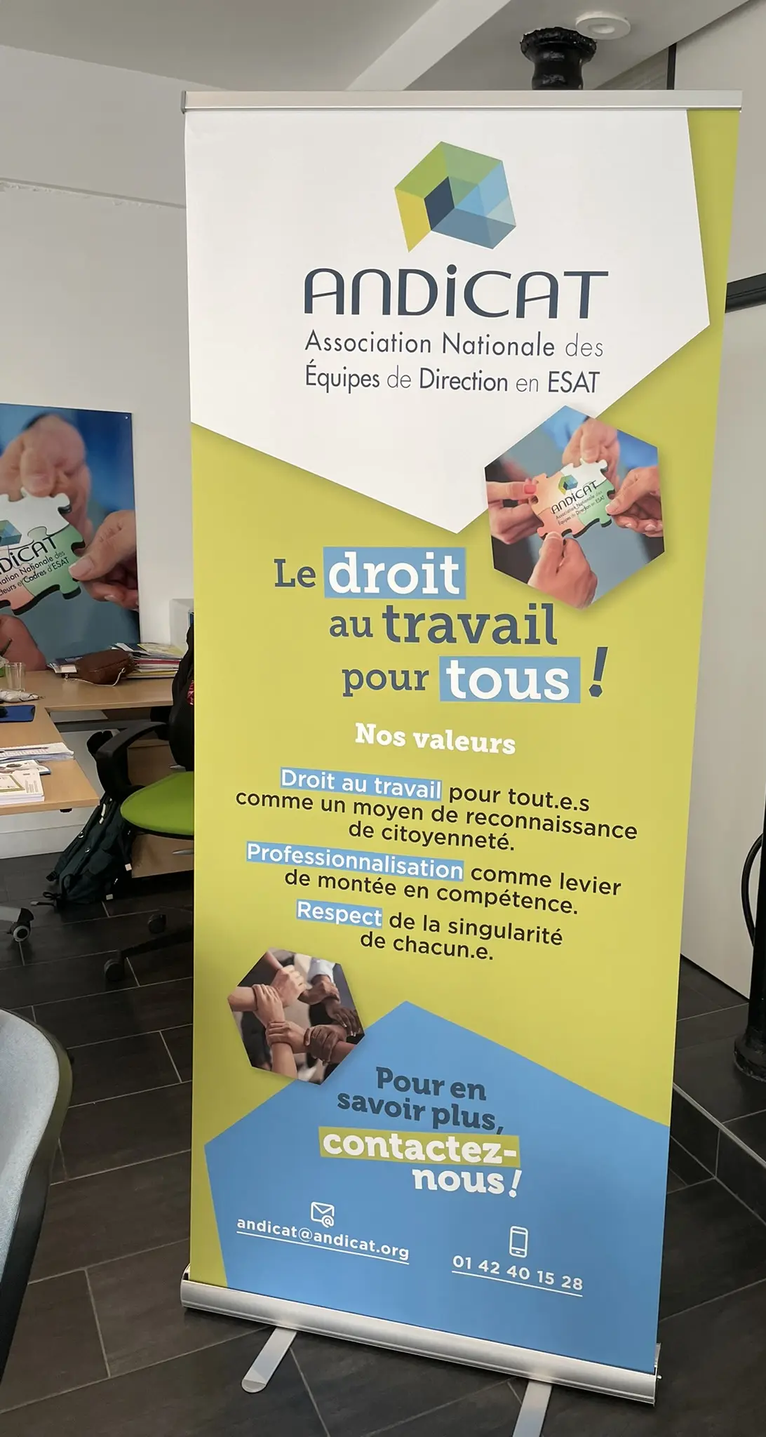 Kakémono ANDICAT présentant ses valeurs et le message « Le droit au travail pour tous » dans un espace intérieur.